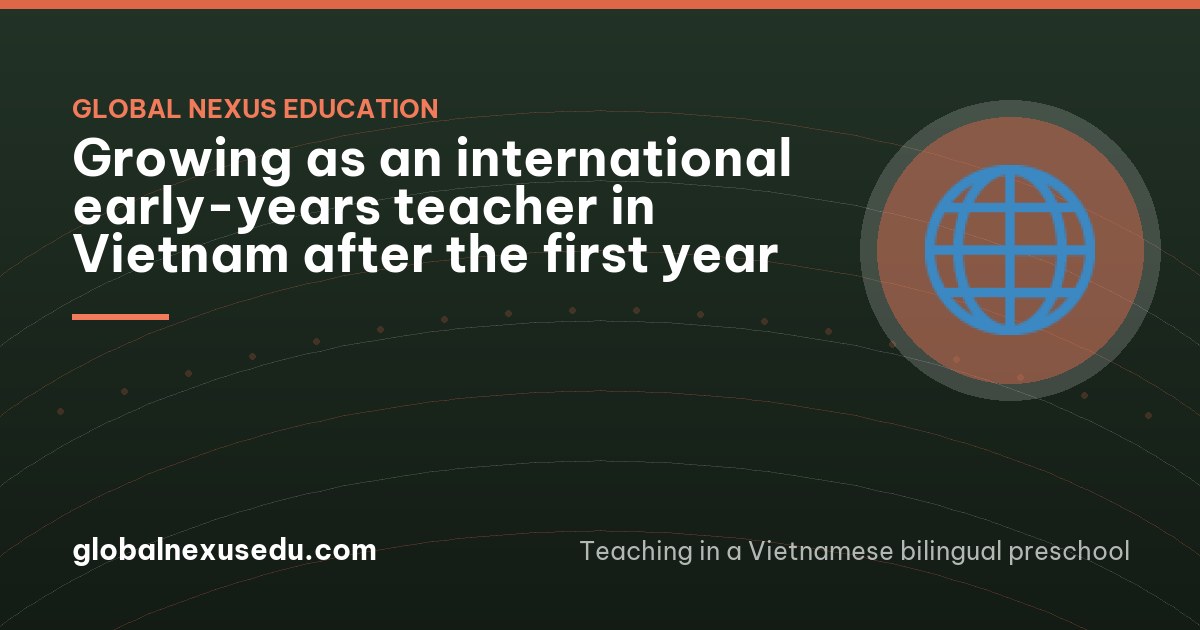 An international teacher and a Vietnamese colleague sitting on child-sized chairs in an empty classroom after school, leaning over a small wooden tray of leaves and stones, talking